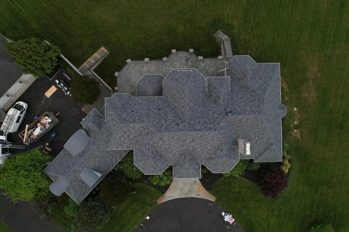 An aerial view shows the full scope of a large, complex shingle roof, the kind of wide shot insurers also rely on.