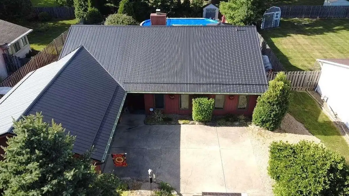 A dark gray standing-seam metal roof tops this home, the longer-lasting option discussed in the durability comparison.