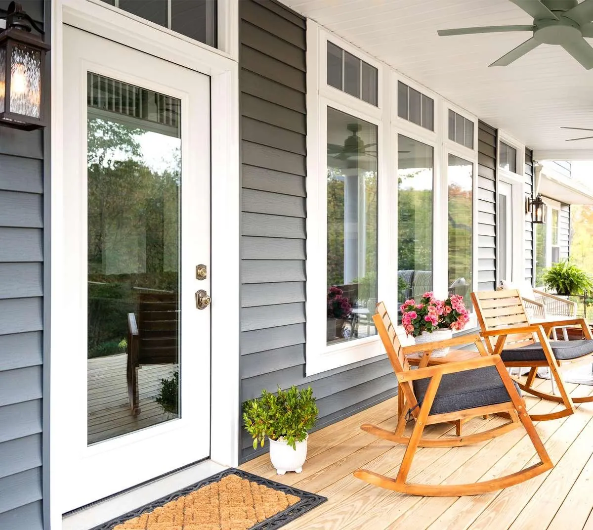 A full-glass entry door on a covered porch with no storm door in front of it, the uncluttered single-door look of a new home.