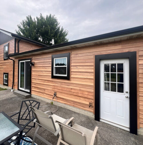 Black seamless gutters and trim on faux wood siding project