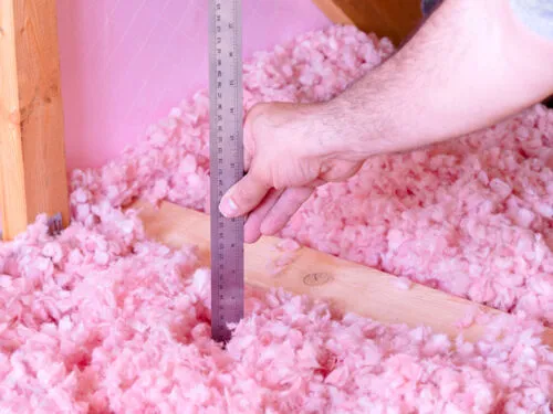 Home Contractor Measures Blown In Attic Insulation