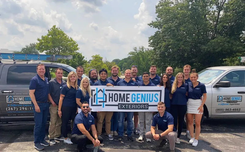 Group of HGE employees posing for a group photo holding a sign with the company logo