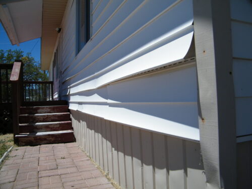 damaged vinyl siding on home exterior