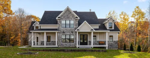 Beautiful suburban home with stonework siding and asphalt shingle roofs