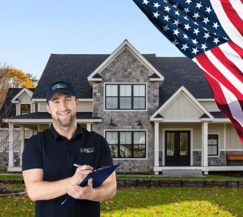 An HGE team member with a clipboard smiling outside a home ready for inspection