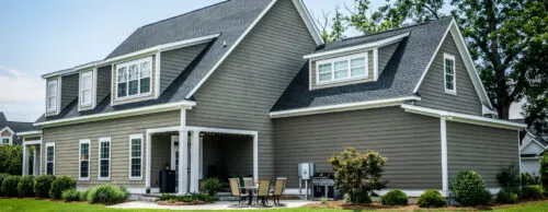 Beautiful home with grey-green vinyl siding and patio doors