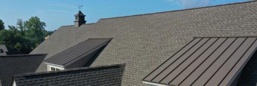 asphalt shingle roofing with metal caps on window extensions