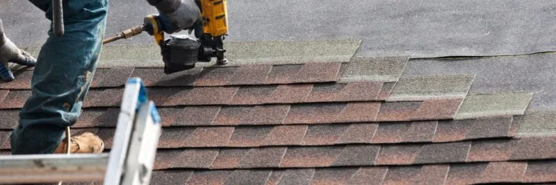 a person using a drill to install shingles