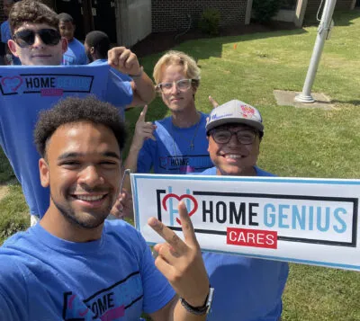 Home Genius team members holding up Home Genius Cares signs