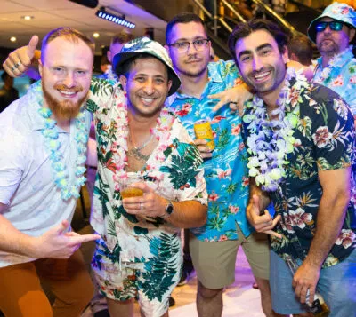 Photo of HGE team members smiling in matching Hawaiian shirts at team bonding event