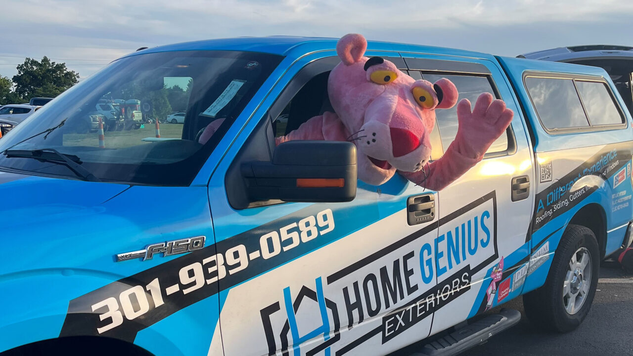 owens corning pink panther mascot in a Home Genius exteriors branded truck