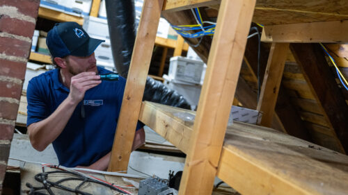 an HRE performing a home inspection in a homeowner's attic
