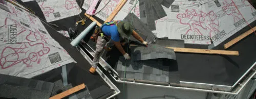 Home Genius Exteriors contractor installing asphalt roofing panels