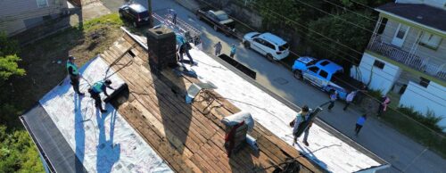 drone shot of a home genius exteriors team working on a roof repair project