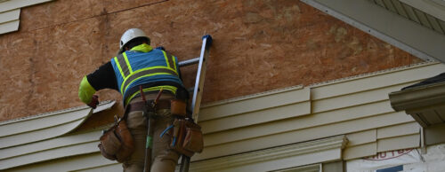 Home Genius exteriors contractor removing vinyl siding during an install project