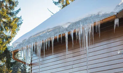 icicles hanging off gutters on a home in winter