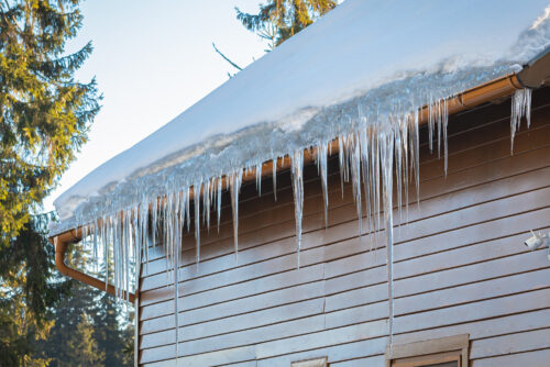 icicles hanging off gutters on a home in winter