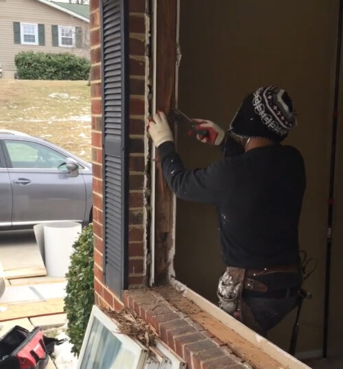 an installation tech removing rotten wood from a window frame