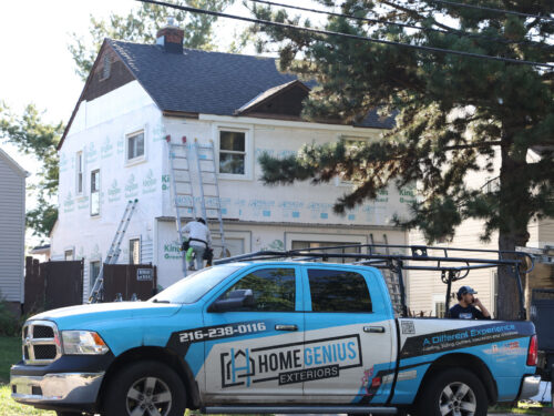 a Home Genius Exteriors wrapped truck at the site of an install