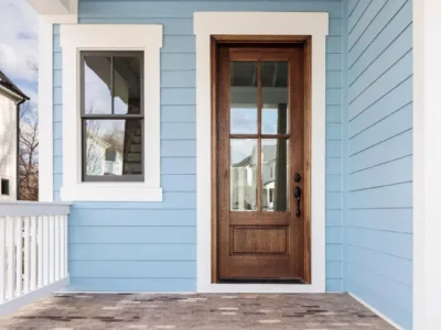 An entry door with a tall glass panel stands in a covered doorway, the subject of this comparison.